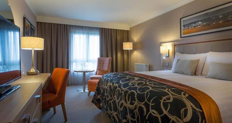 Hotel room with a comfortable double bed and a desk.