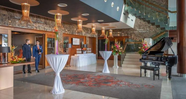 Hotel lobby with a grand piano and elegant decor.