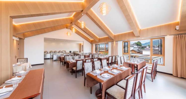 Lichte eetkamer met meerdere tafels gedekt voor maaltijden.