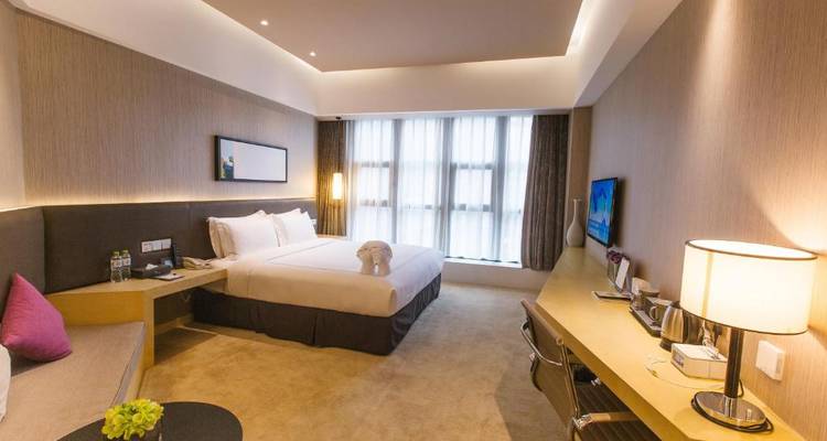 Elegante hotelkamer met een groot bed en doorzichtige gordijnen.