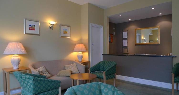 Coin salon d'hôtel confortable avec des sièges et une réception.