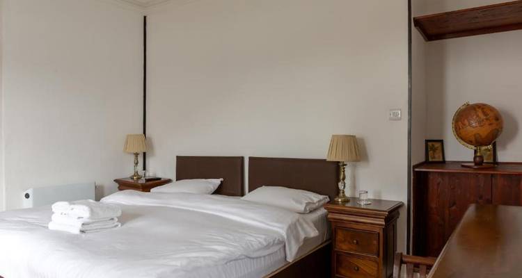 Chambre d'hôtel avec un lit double, des meubles en bois et une décoration de globe.