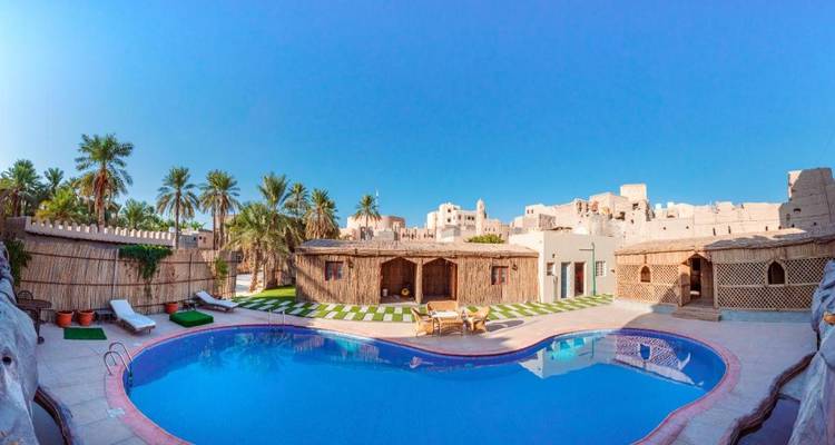 Zone de villégiature traditionnelle avec une piscine entourée d'architecture rustique.