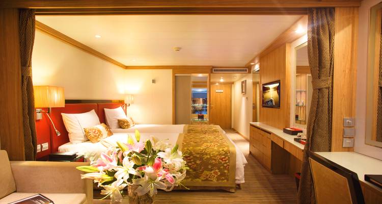Gemütliches Hotelzimmer mit warmer Beleuchtung und Blumendekoration.