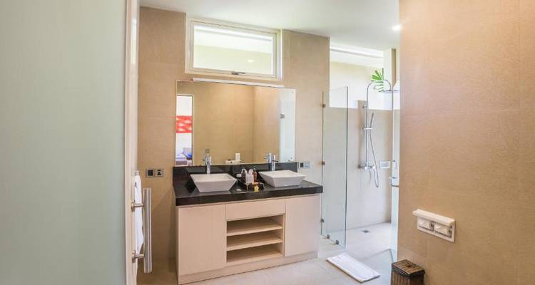 Modern bathroom with dual sinks and shower.