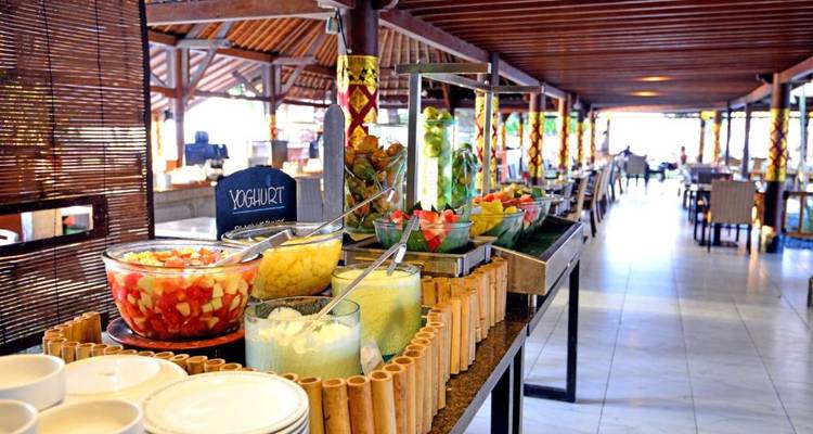 Buffet setup with various food items including yogurt and fruit.