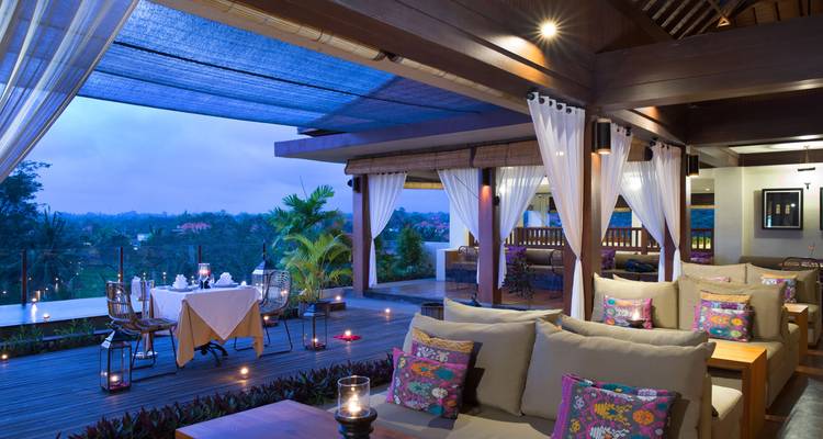Luxury dining area with sofas and a view of greenery.