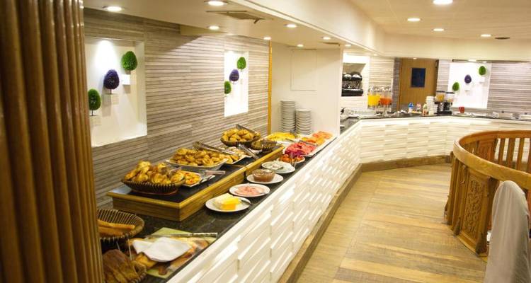 Montaje de buffet con varios platos en un comedor bien iluminado.