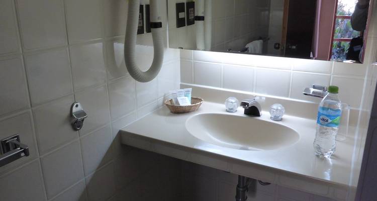 Baño pequeño con amenidades limitadas y una pared de azulejos.