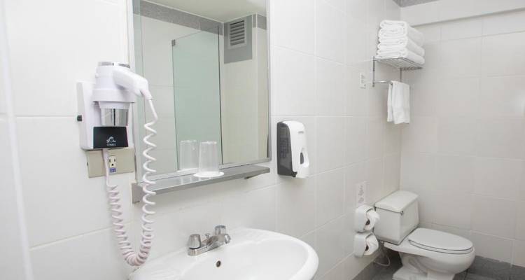 Configuración básica de baño con lavabo, inodoro y ducha.