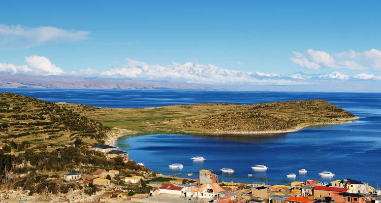 Panoramic view of Lake Titicaca with boats and distant mountains.