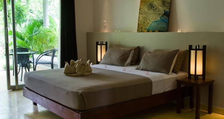 Modernes Schlafzimmer mit Gartenblick und schlichter Einrichtung.