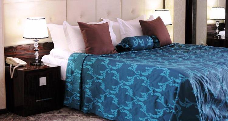 Chambre d'hôtel élégante avec un couvre-lit bleu moelleux.