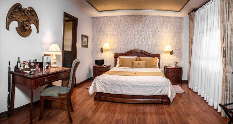 Una habitación acogedora con muebles clásicos y papel tapiz decorativo.