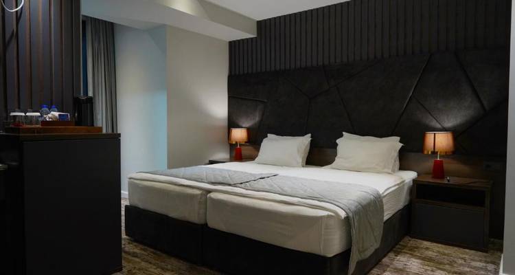 Modernes Hotelzimmer mit Doppelbett und minimaler Dekoration.