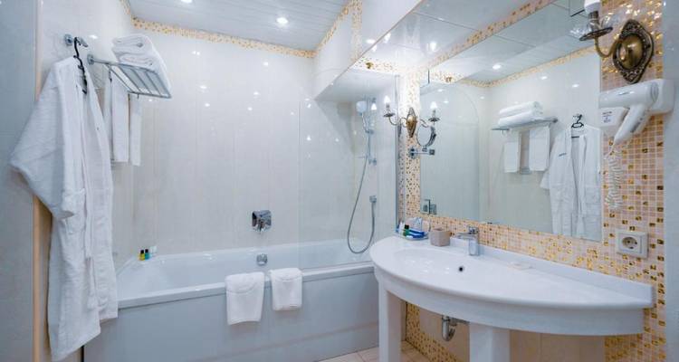 Modernes Badezimmer mit Badewanne und großem Spiegel.