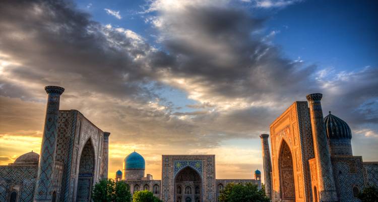 Ikonische islamische Architektur mit blauen Kuppeln und Bögen unter einem dramatischen Himmel.