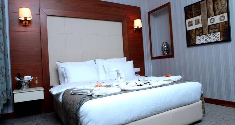 Elegantes Hotelzimmer mit Schwanen-Handtuchdekorationen auf dem Bett.