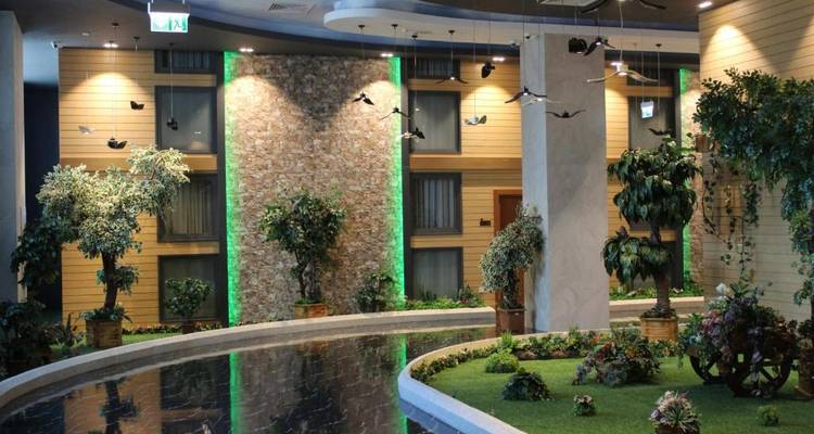 Jardin artificiel intérieur avec des plantes et un petit point d'eau.