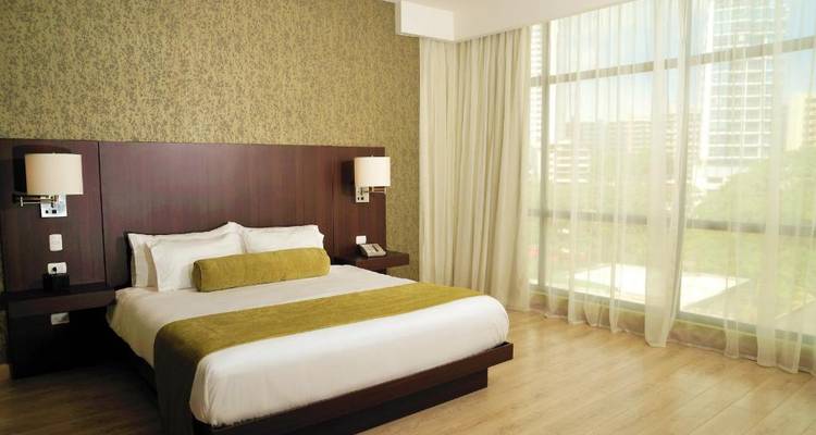 Chambre d'hôtel avec un grand lit et vue sur la ville.