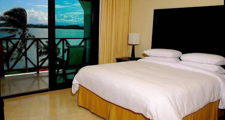 Chambre d'hôtel avec balcon et vue sur l'océan.