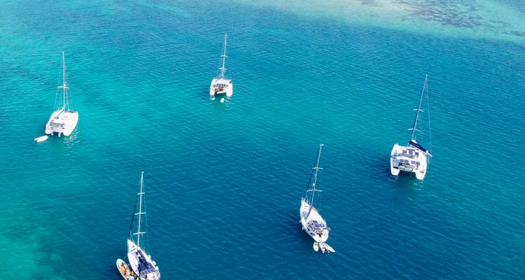 Voiliers ancrés dans des eaux bleu clair.