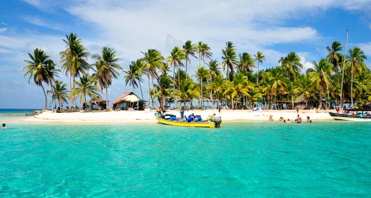 Isla tropical con palmeras y aguas turquesas.