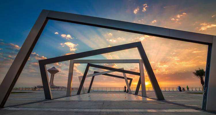 Modern walkway with sunset view and patterned shadows.