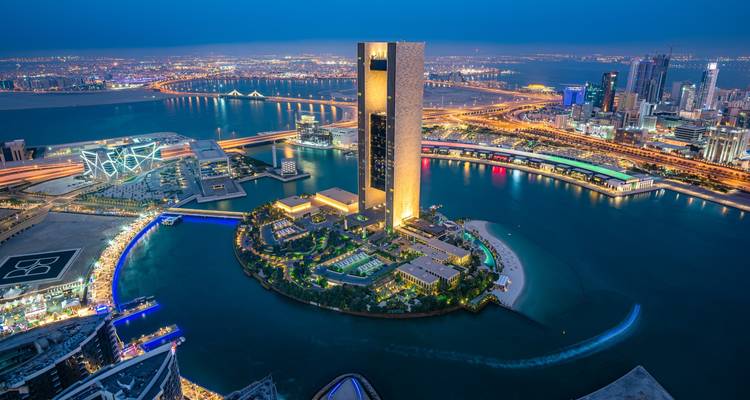 Modern city skyline with illuminated buildings and waterfront views.