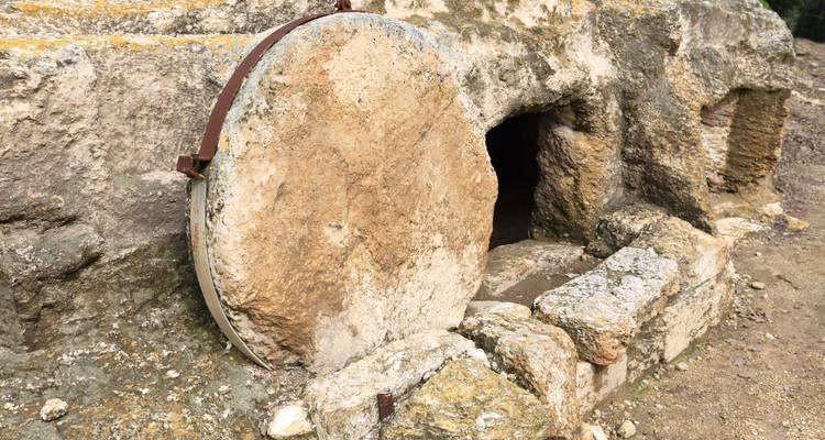 Une tombe en pierre avec une grande entrée circulaire en pierre.