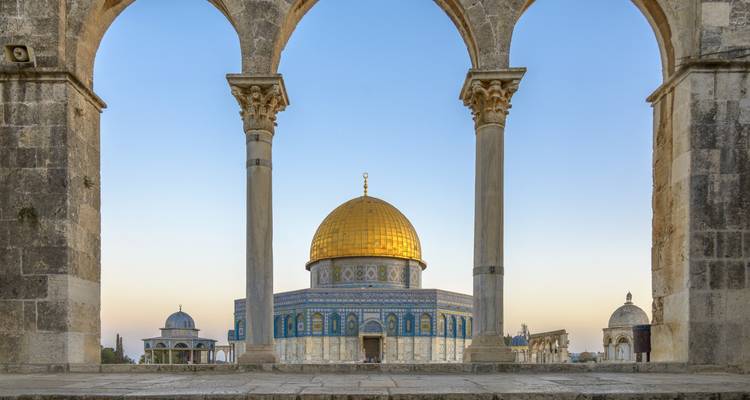 Bâtiment emblématique au dôme doré encadré par des arches.