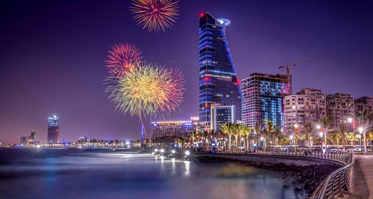 City skyline lit up at night with fireworks.