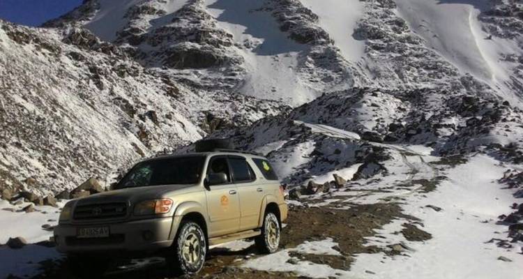 Voiture sur une route de montagne enneigée.