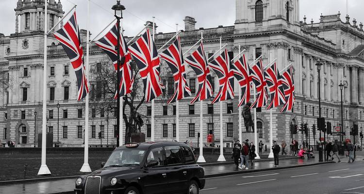 Union Jack Flaggen vor einem historischen Gebäude.