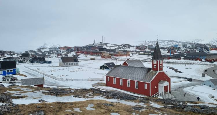 Snow-covered town with a red church in Greenland.