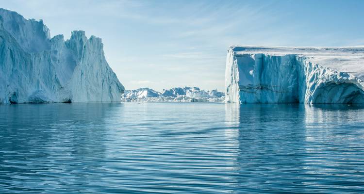 Des icebergs imposants dans les eaux calmes de l'océan.