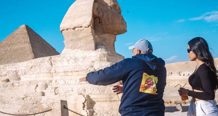 Turistas cerca de la Esfinge con la Gran Pirámide en el fondo.
