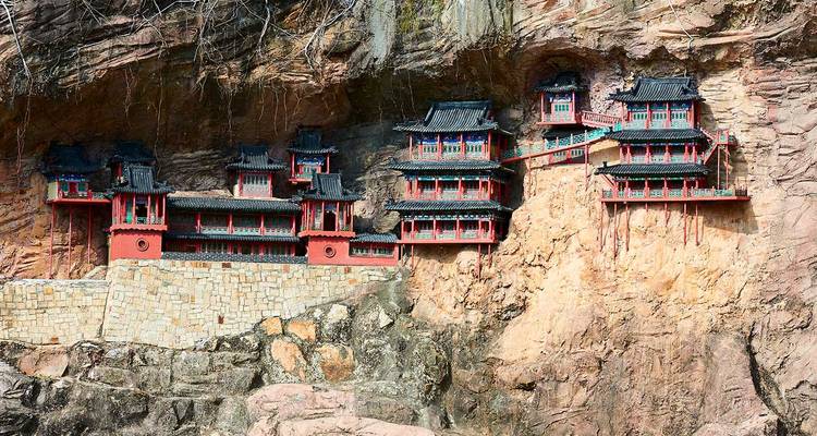 Hanging temples built against a cliff face.