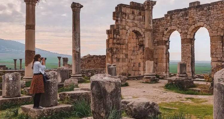 Une personne photographiant des ruines antiques.