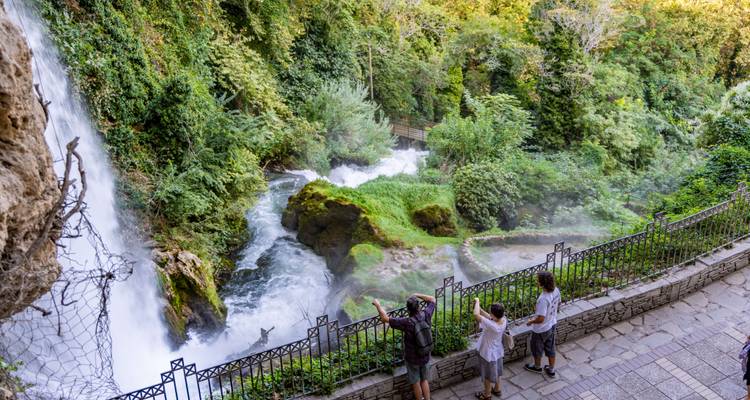 Les visiteurs admirent une puissante cascade qui se déverse dans une gorge verdoyante luxuriante