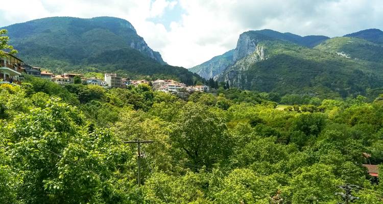 Village de montagne niché parmi de denses forêts vertes et des pics spectaculaires