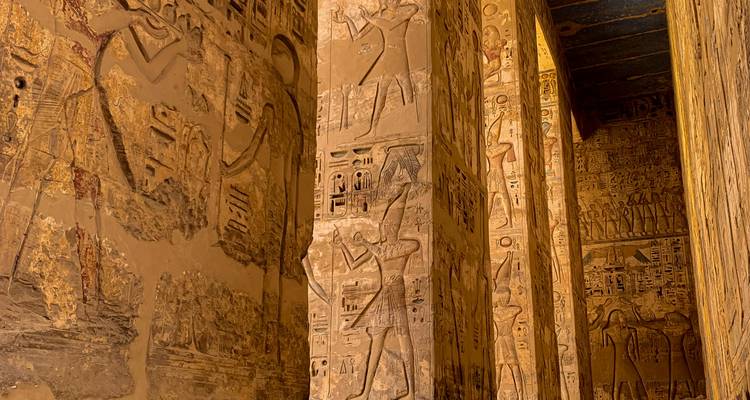 Gedetailleerde weergave van oude Egyptische hiërogliefen op zandstenen pilaren.