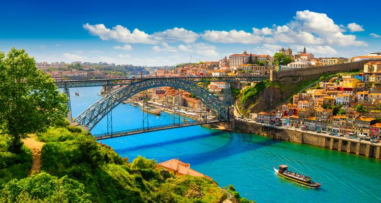 Aerial view of the Douro River and Dom Luís I Bridge with colorful buildings along the riverbank.