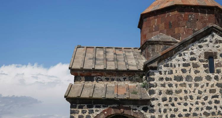 Vue partielle d'une église historique avec un ciel nuageux.