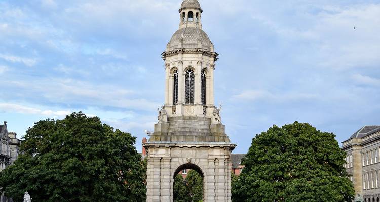Klokkentoren van een universiteitscampus te midden van bomen.