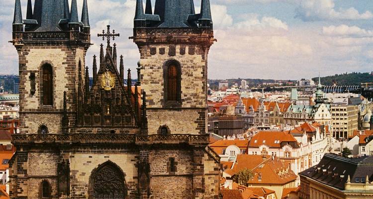 Gotische kerktoren torent uit boven een stadsgezicht.