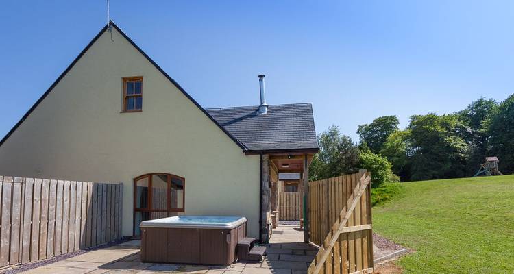 Extérieur de maison avec un spa et une pelouse.