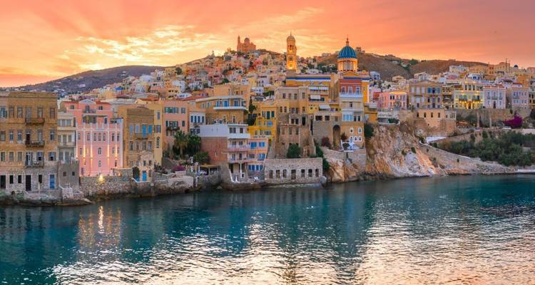 Bunte Pastellgebäude entlang der Küstenlinie bei Sonnenuntergang.