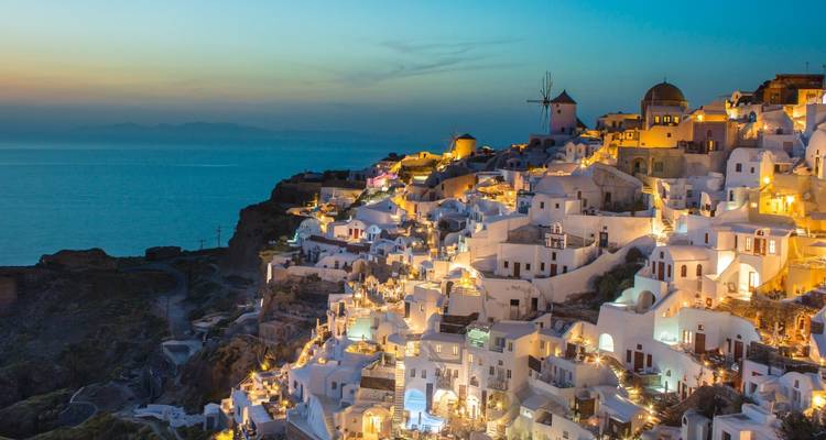 Ikonischer Santorini-Blick in der Dämmerung mit warmen Lichtern.