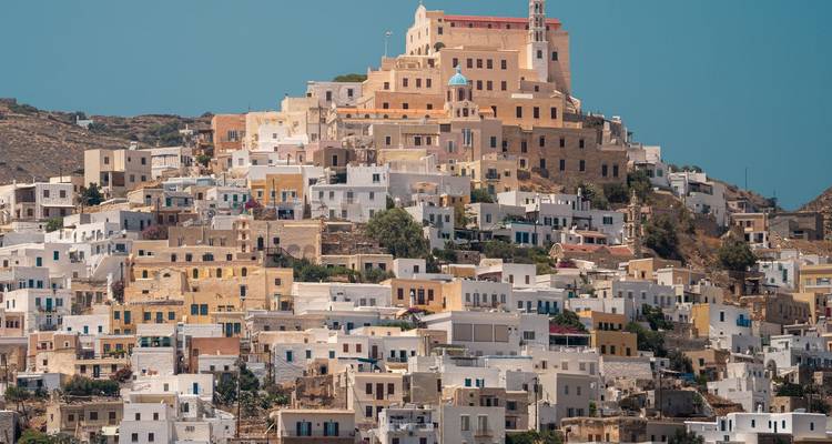 Ein Hügel bedeckt mit traditionellen griechischen Häusern in verschiedenen Farben.